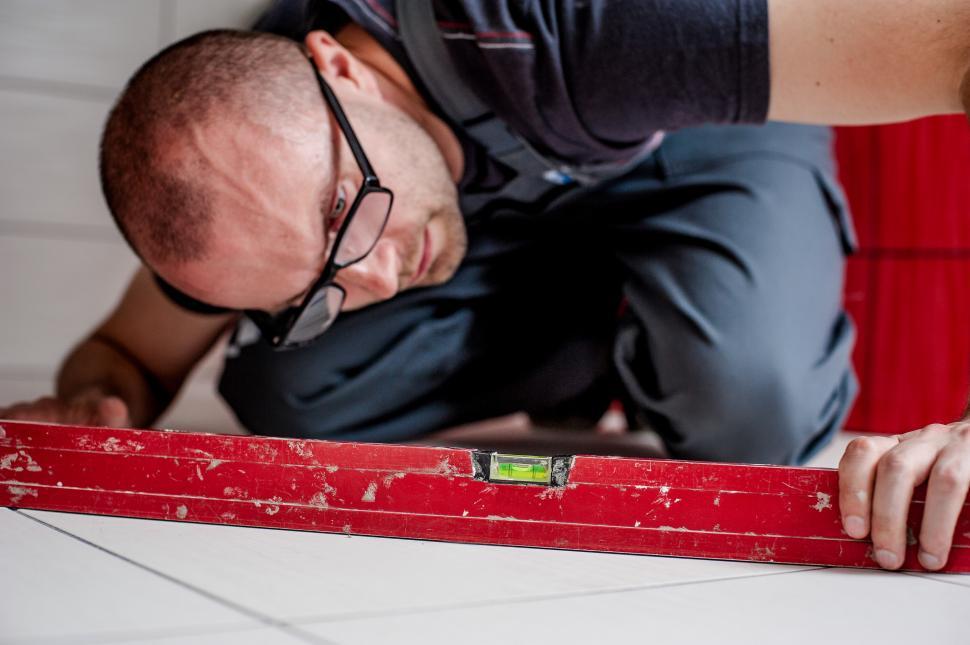 Free Image of Man Bending Over Red Metal 