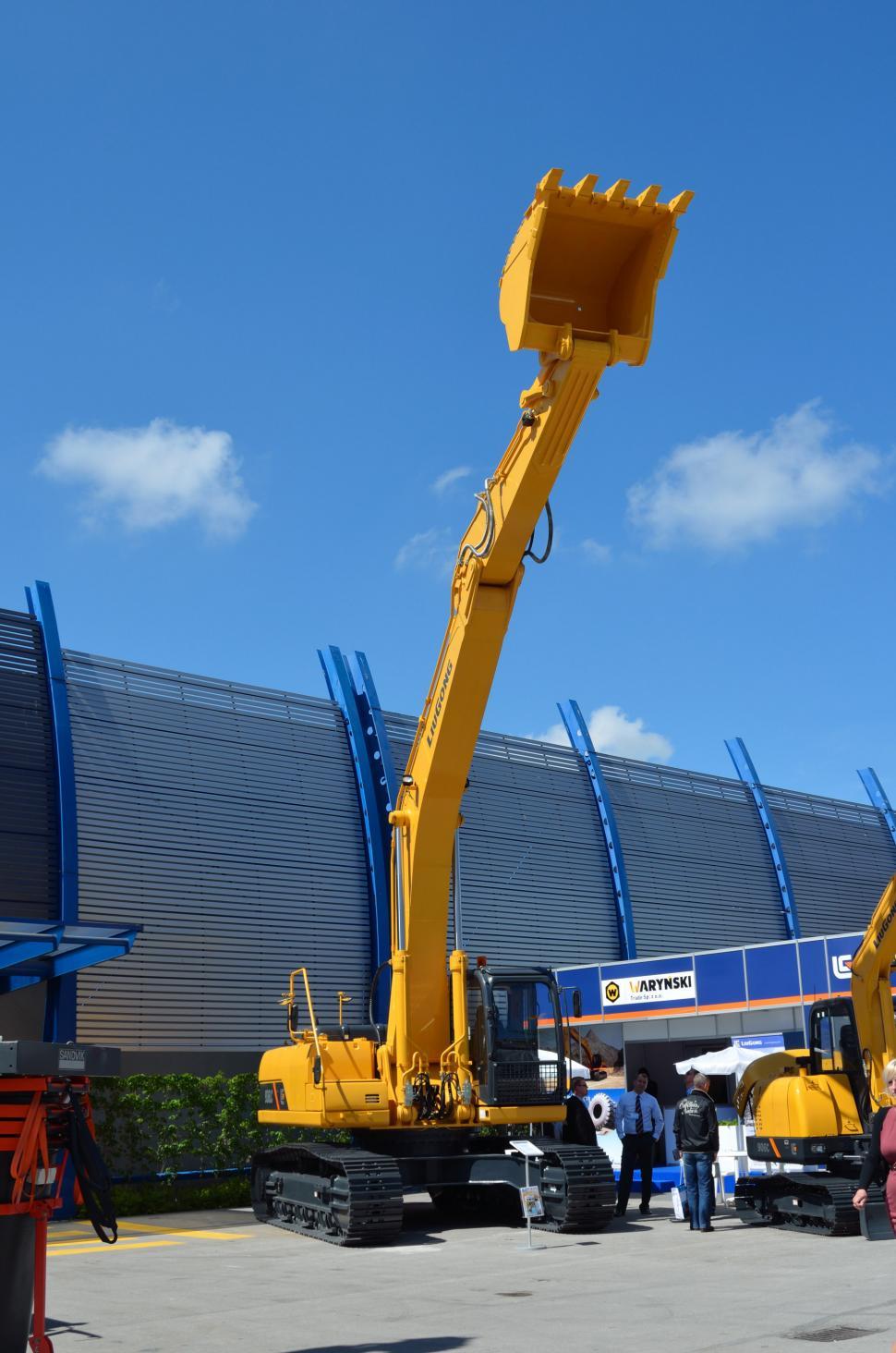 Free Image of Man Standing Next to Yellow Crane 
