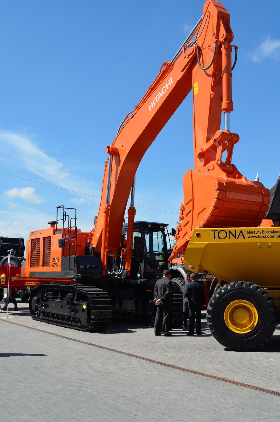 Free Image of Group of Men Standing Next to a Large Orange Truck 