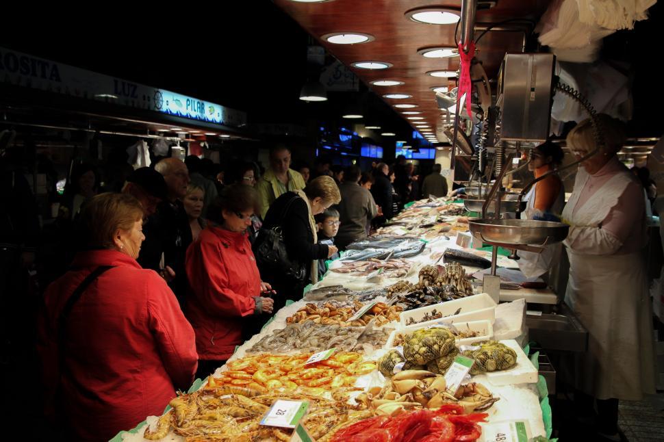 Free Image of Group of People Standing Around Table With Food 
