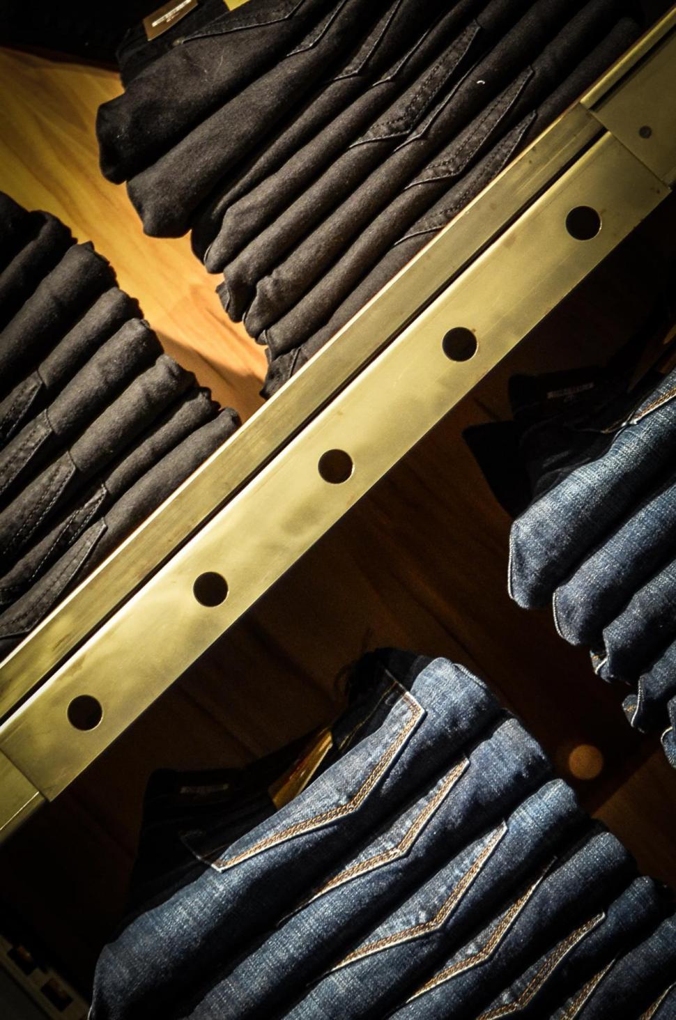 Free Image of Several Pairs of Jeans Stacked on Shel 