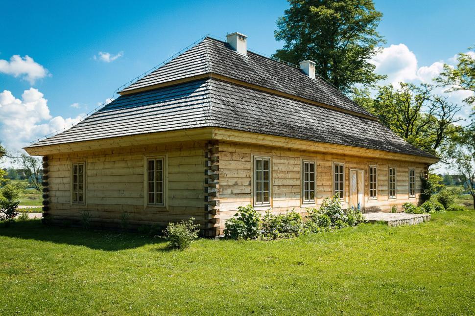Free Image of Small Log Cabin on Lush Green Field 