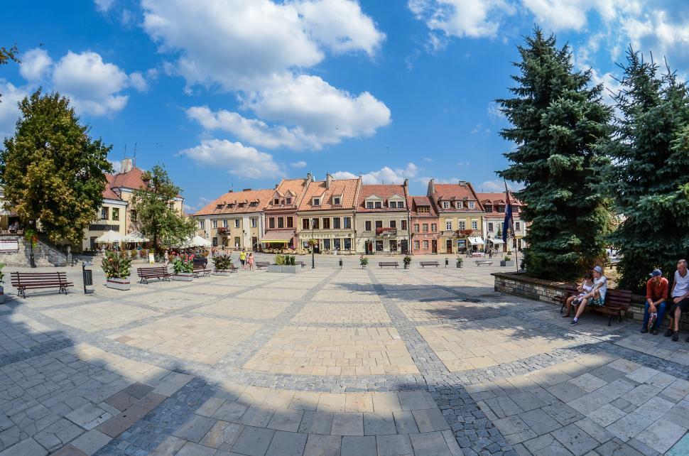 Free Image of Group of People Sitting on a Bench in a Courtyard 