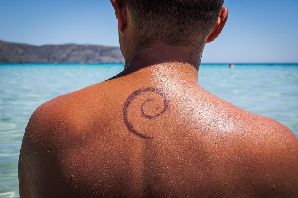 Free Image of Man With Tattoo Standing in Water 