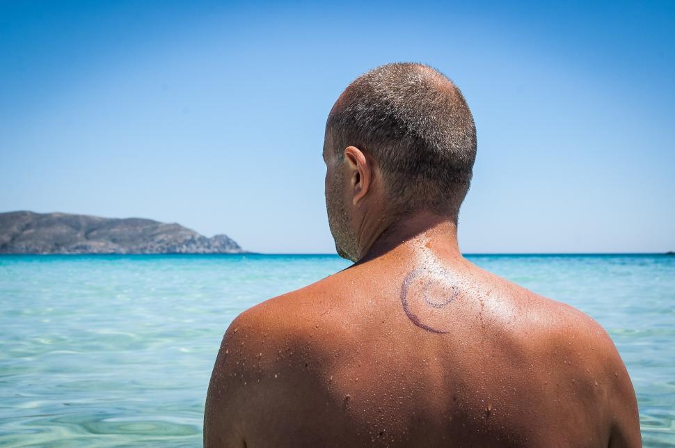 Free Image of Man With Tattoo Standing in Water 