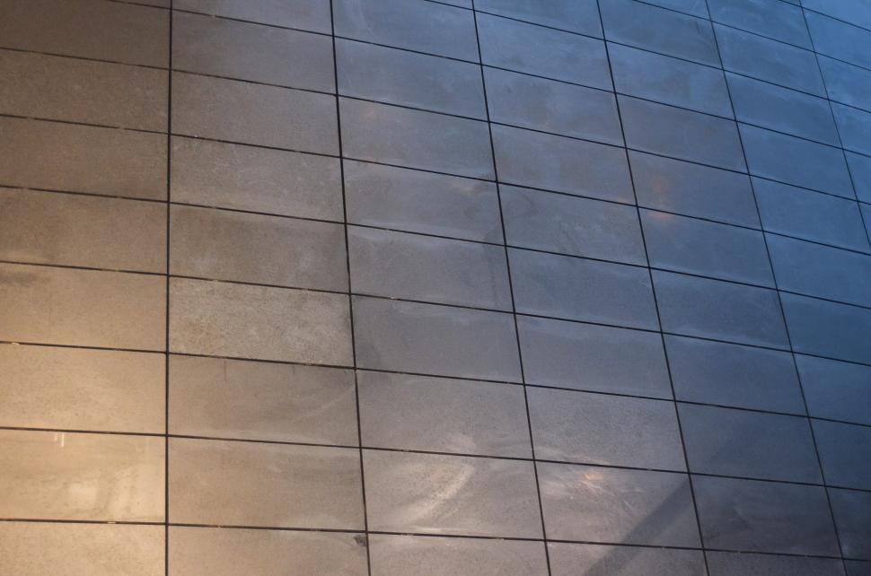 Free Image of Person Standing on Tiled Floor With Cell Phone 