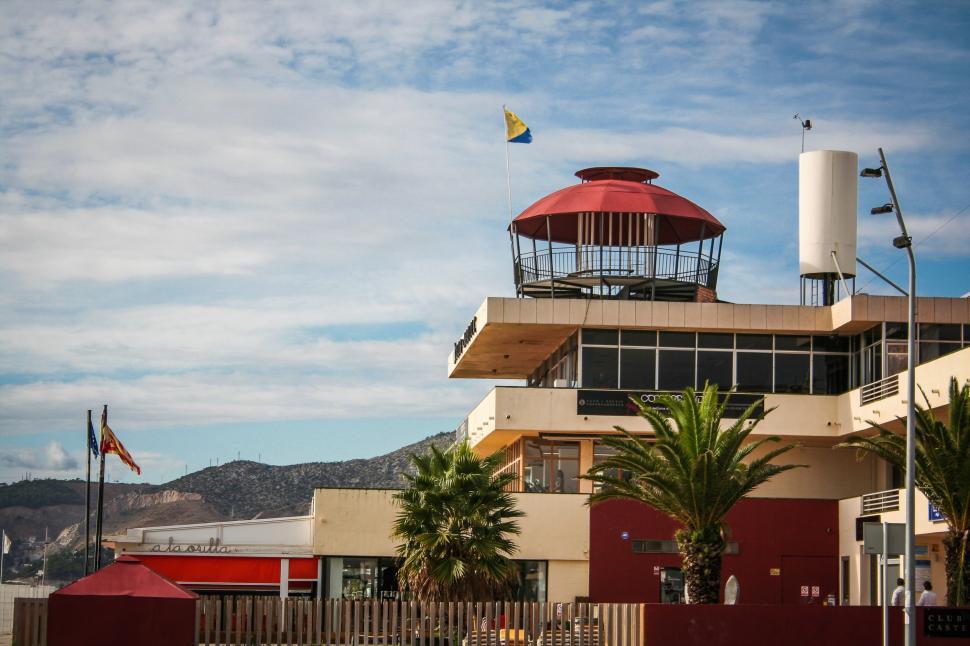 Free Image of Red and White Building With Red Umbrella 