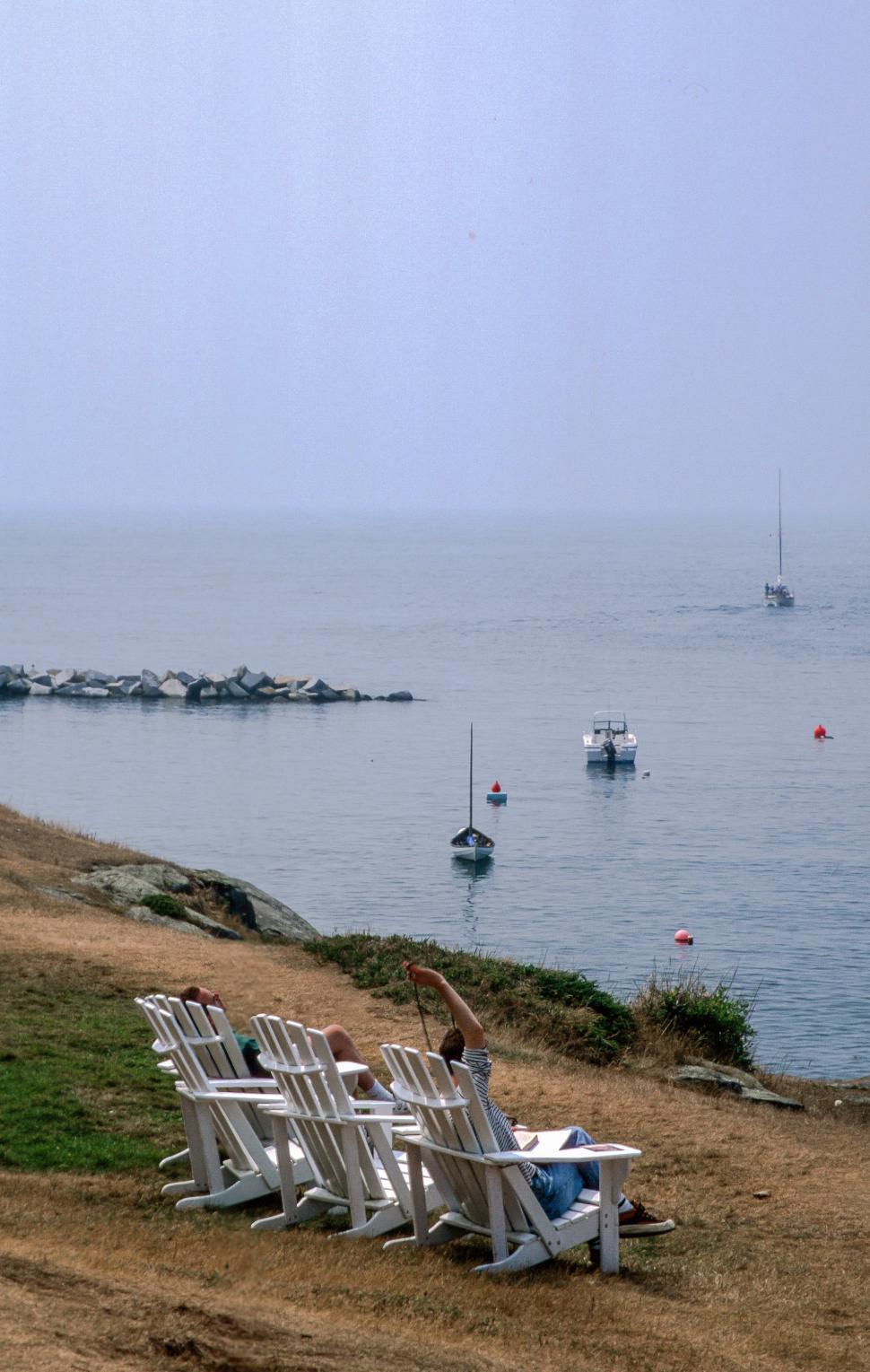 Free Image of Three people sitting on beach chairs 