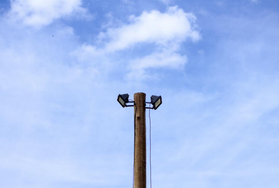 Free Image of Two spotlights atop a wooden post 