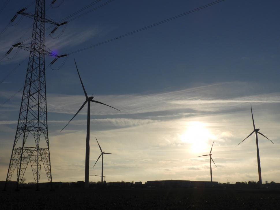 Free Image of Four wind turbines and a power line mast  
