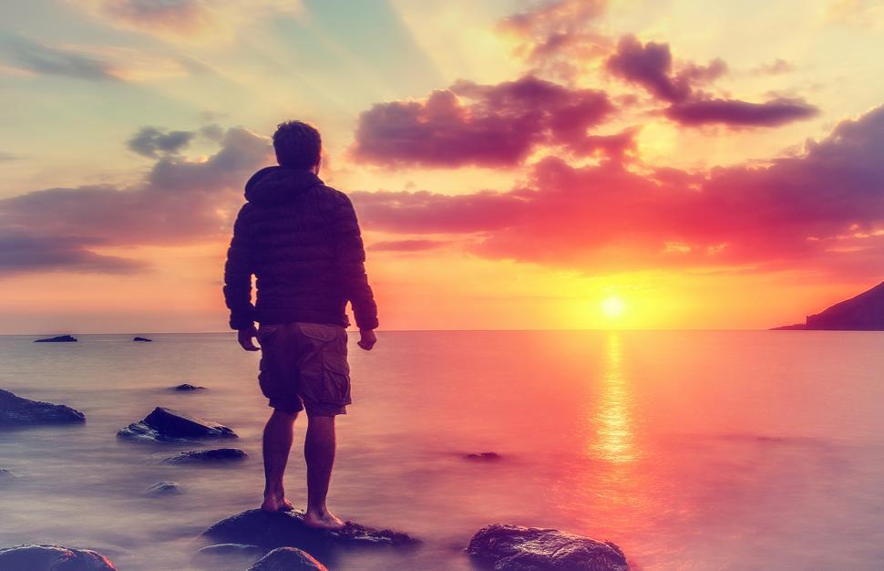 Free Image of Young Man Watching the Sunrise at Rocky Beach 