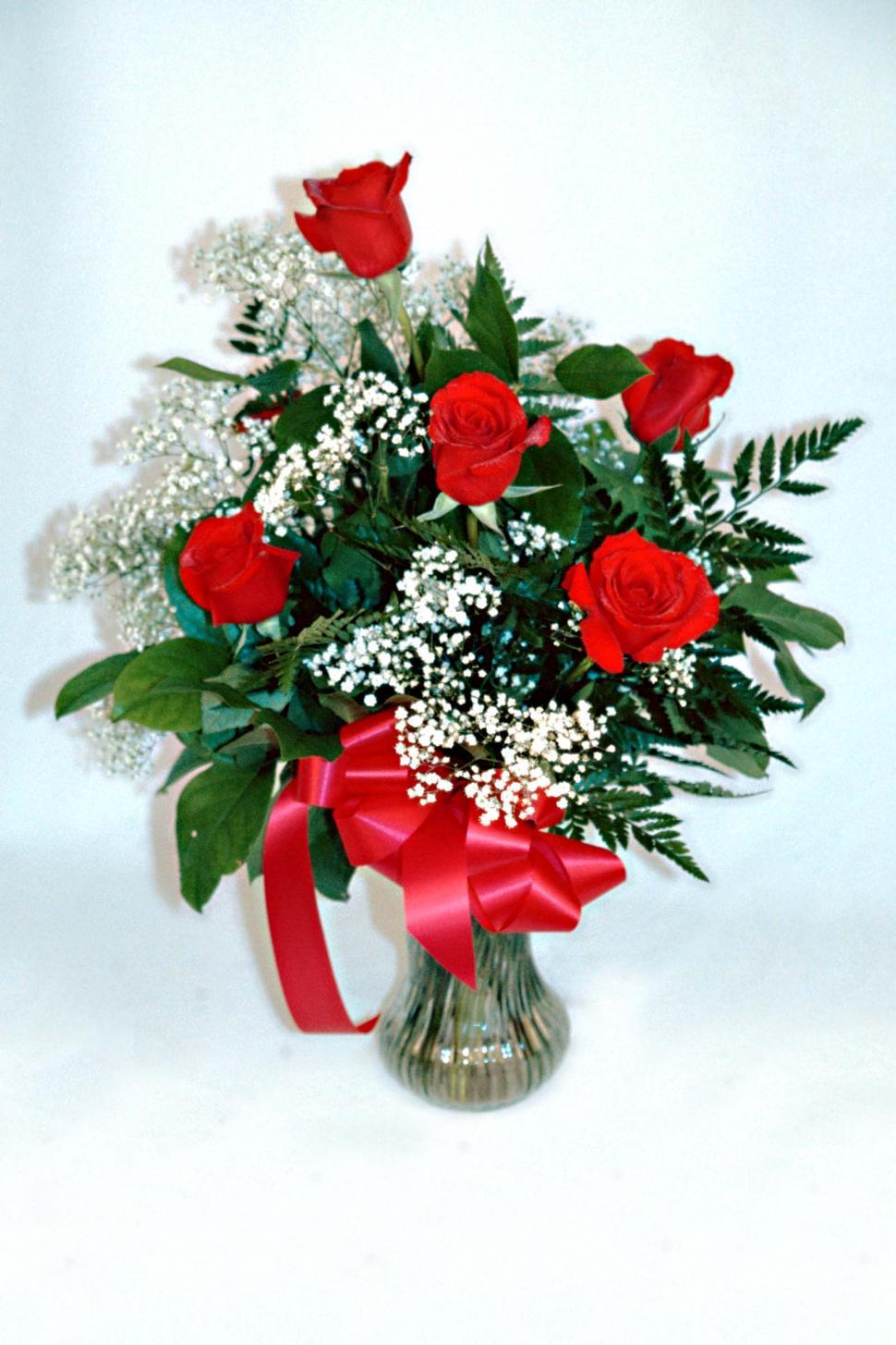Free Image of Vase Filled With Red Roses and Babys Breath 