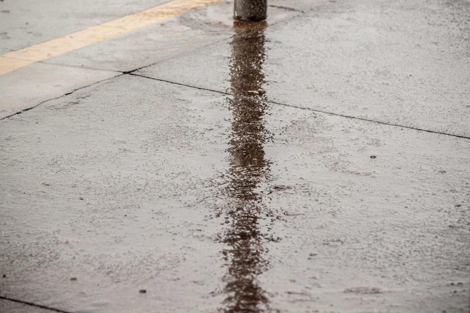 Free Image of Lamp post reflection on rainy ground 