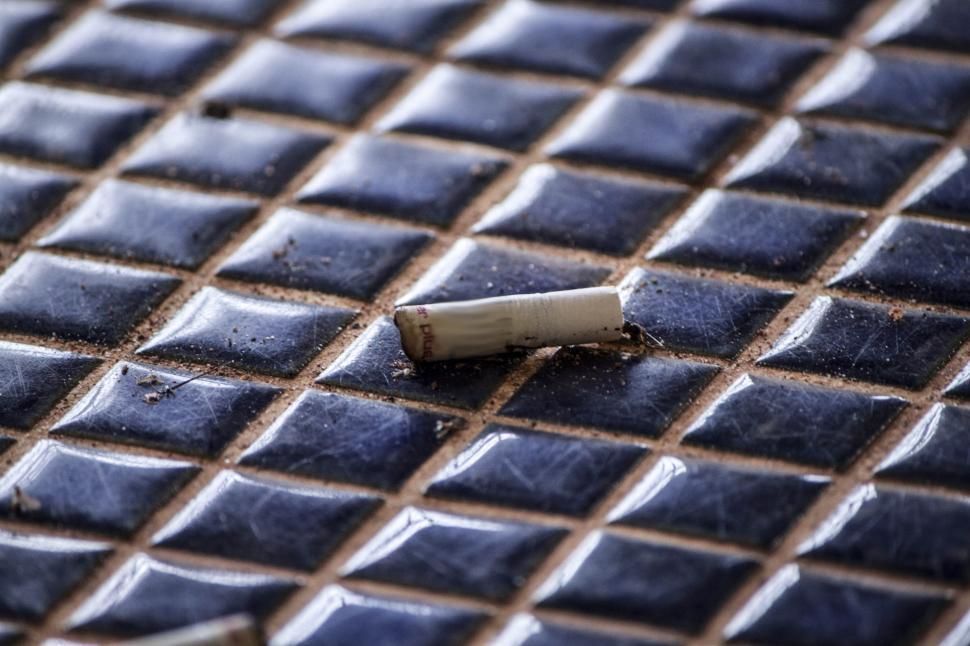 Free Image of Cigarette Resting on Tiled Floor 