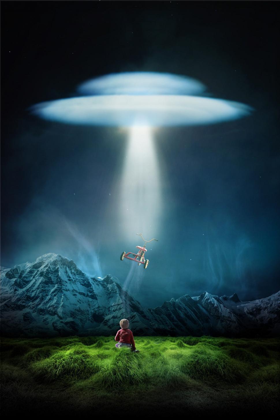 Free Image of Man Sitting in Field Watching a Flying Object 