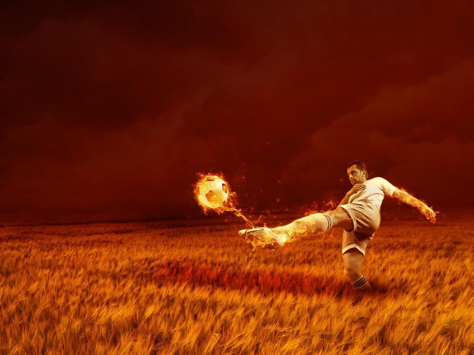 Free Image of Man Kicking Soccer Ball in Field 