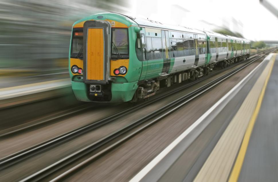 Free Image of Green and Yellow Train Traveling Down Train Tracks 