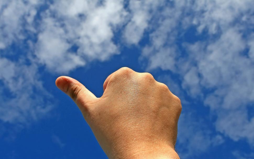 Free Image of Hand Reaching Up to Catch Frisbee in Sky 