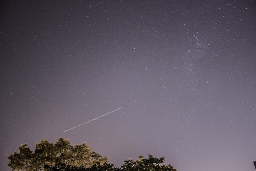 Free Image of Plane flying through star filled skies 
