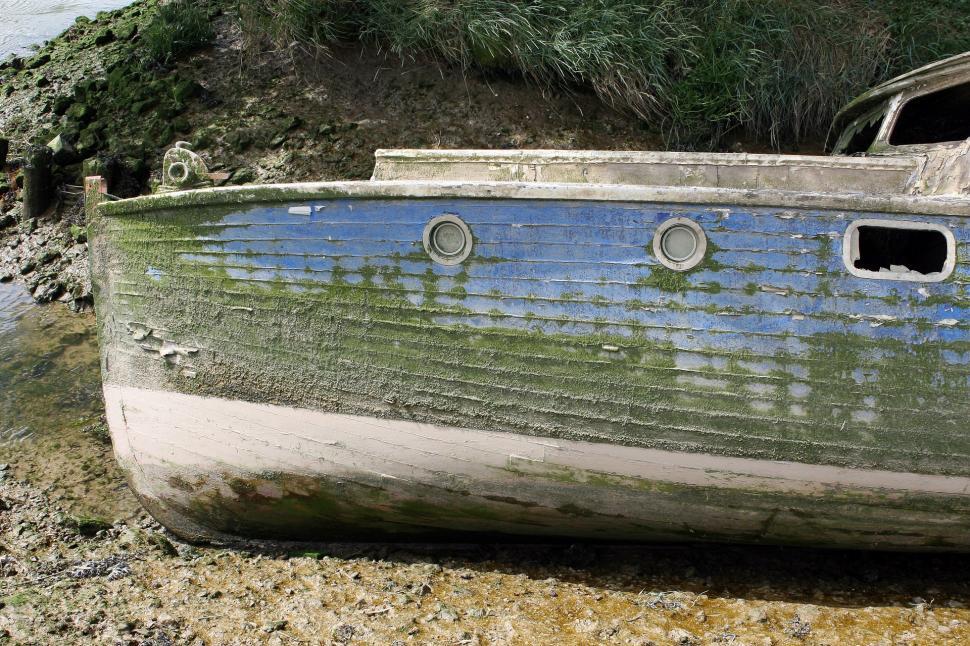 Free Image of Boat Resting on Beach by Waters Edge 