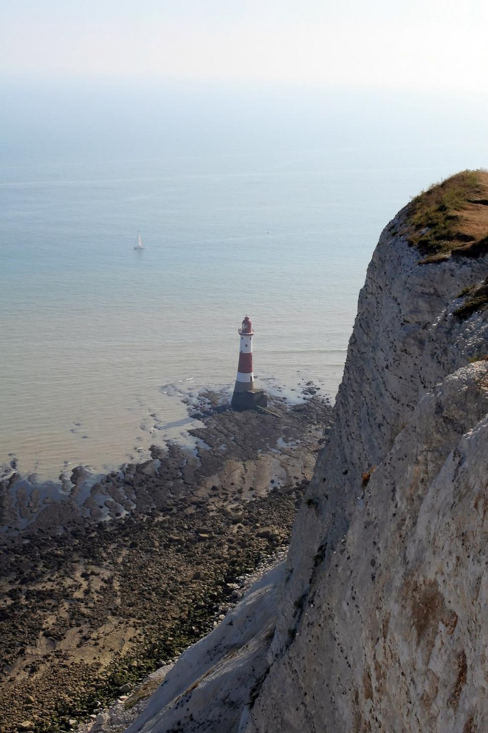 Free Image of Lighthouse on a Rocky Cliff Overlooking a Body of Water 