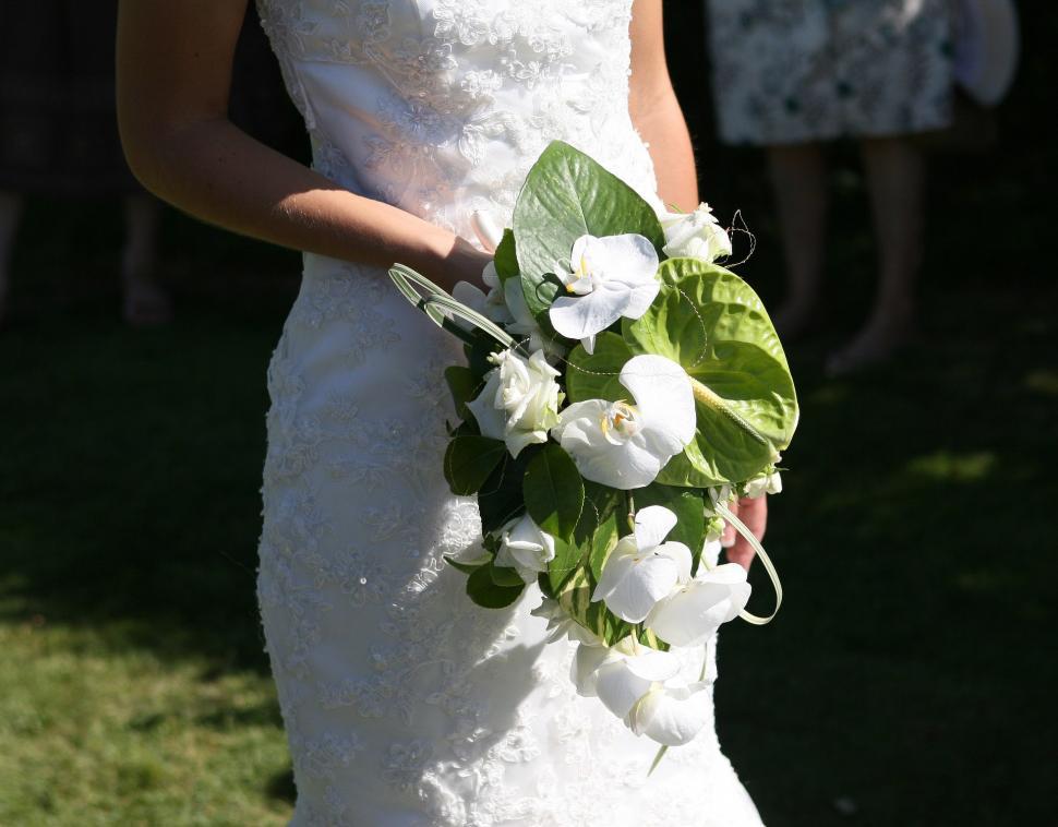 Free Image of Woman in Wedding Dress Holding Bouquet of Flowers 