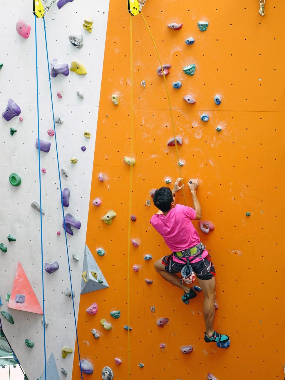 Free Image of Man Climbing Up Side of Climbing Wall 