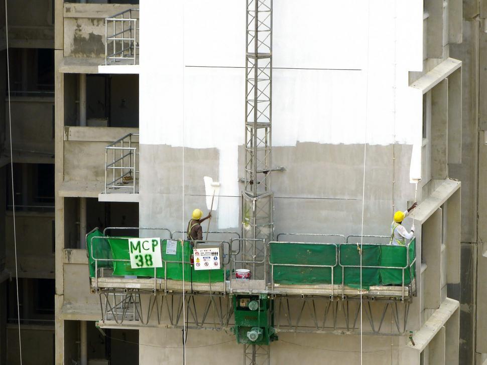 Free Image of Two Men Standing on Top of a Tall Building 
