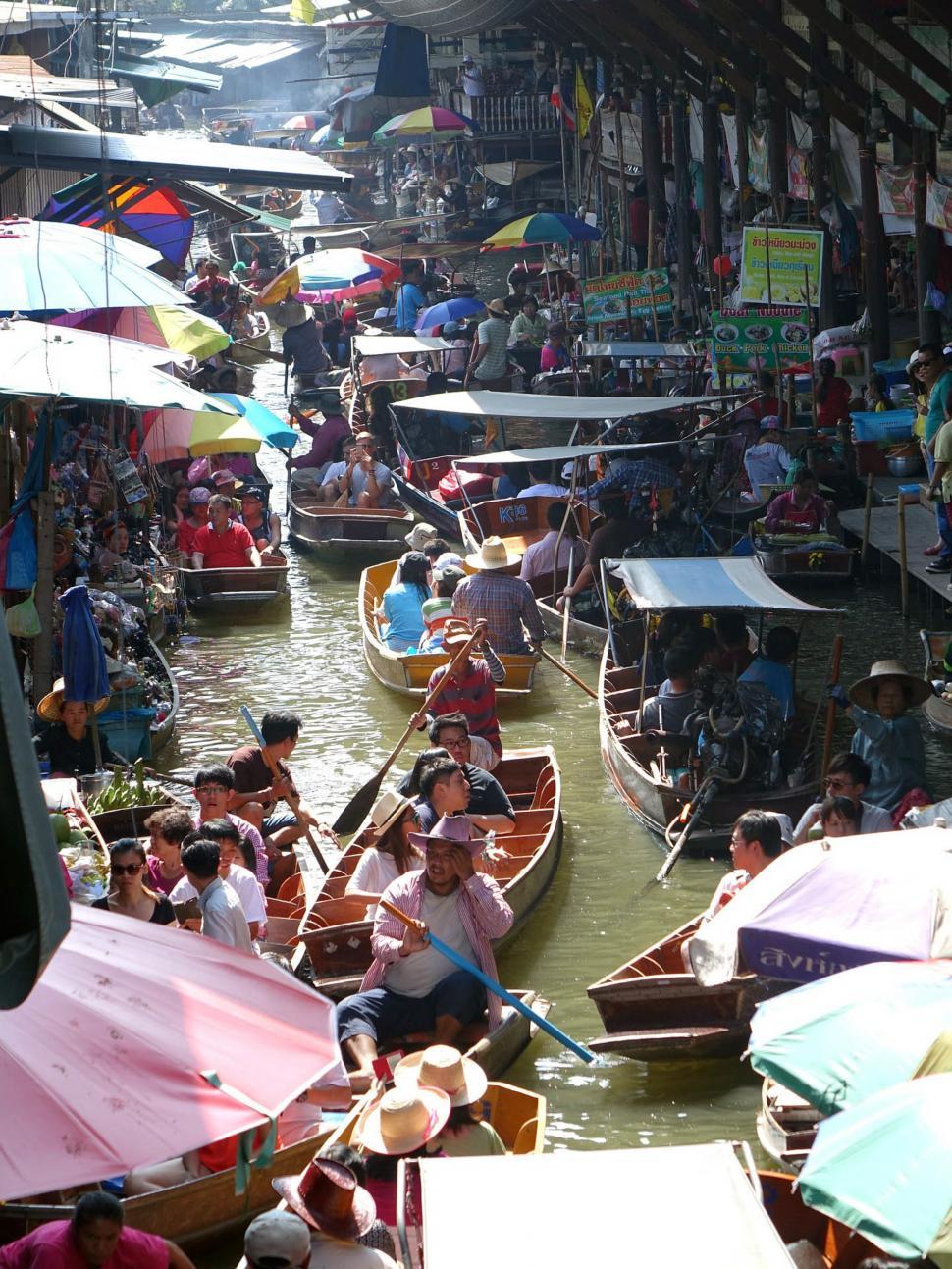Free Image of Group of People Riding on Top of Boats Down a River 
