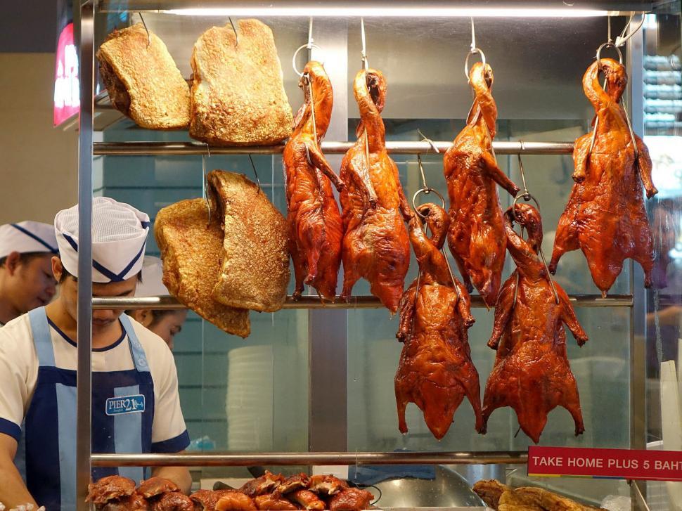 Free Image of Man Standing in Front of Meat Display 