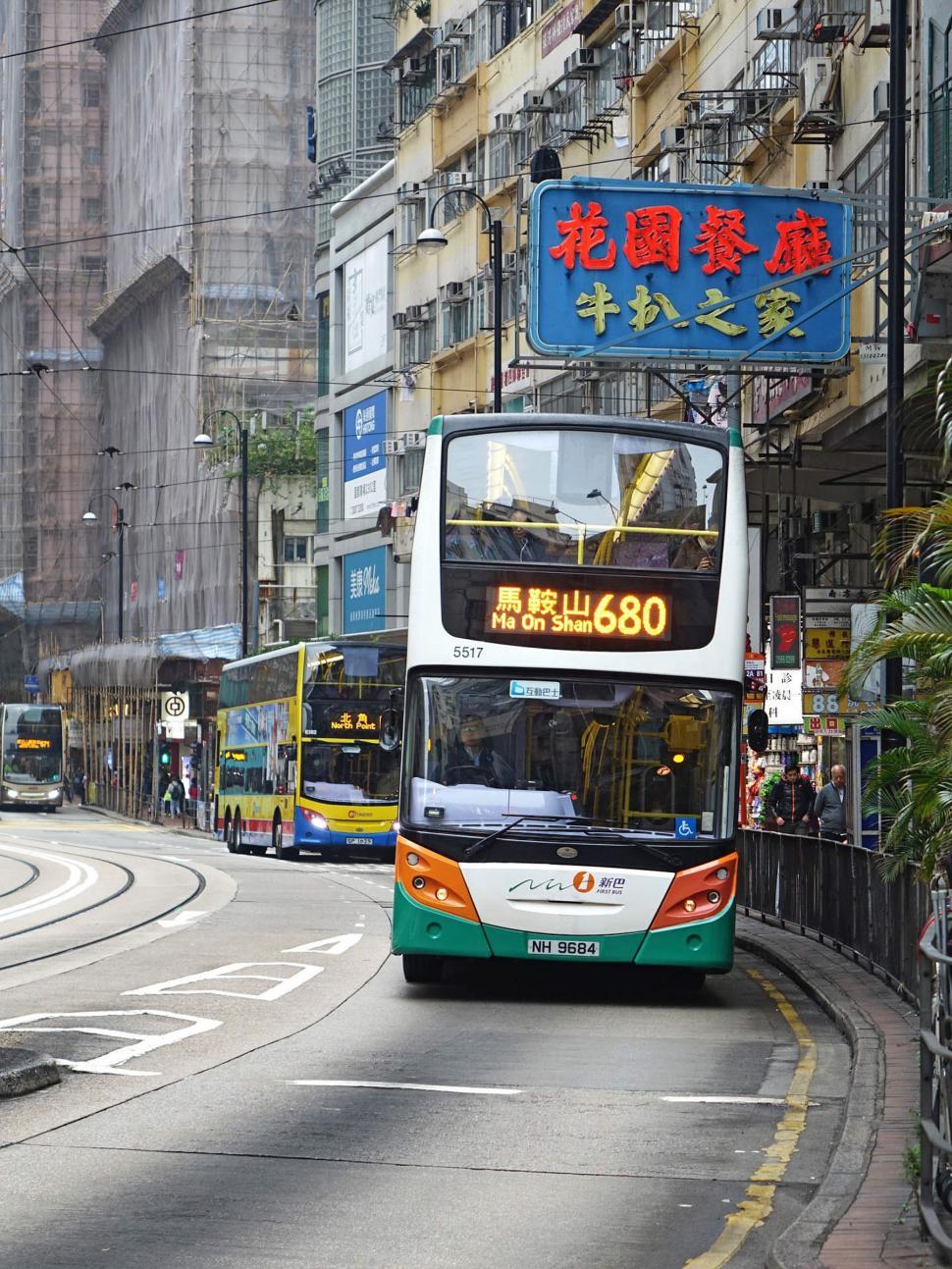 Free Image of Double Decker Bus Driving Down City Street 