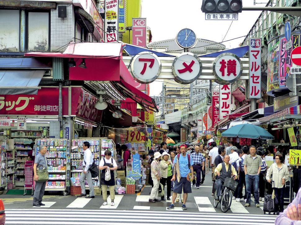 Free Image of Group of People Walking Down City Street Next to Tall Buildings 