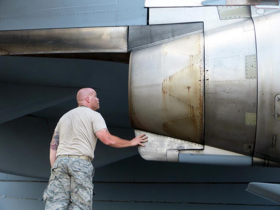 Free Image of Man Standing Next to Large Jet Engine 