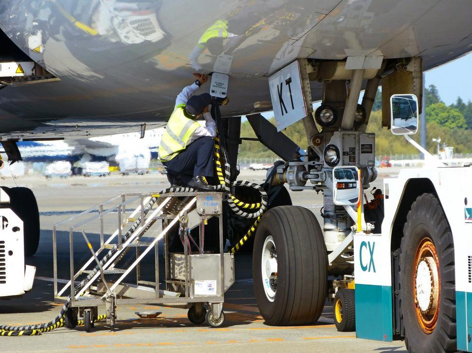 Free Image of Man Working on Large Airplane on Tarmac 