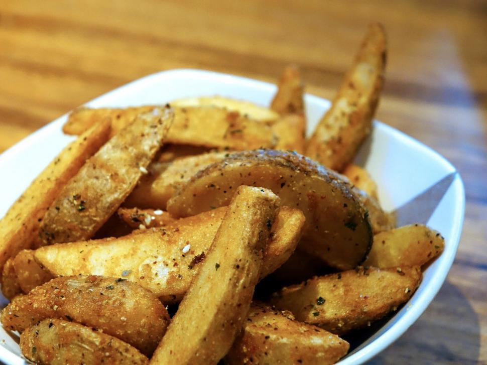 Free Image of White Bowl Filled With Fries on Wooden Table 