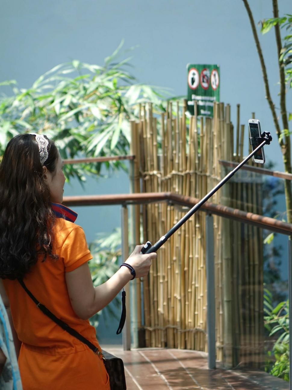 Free Image of Woman Taking a Picture of a Giraffe 