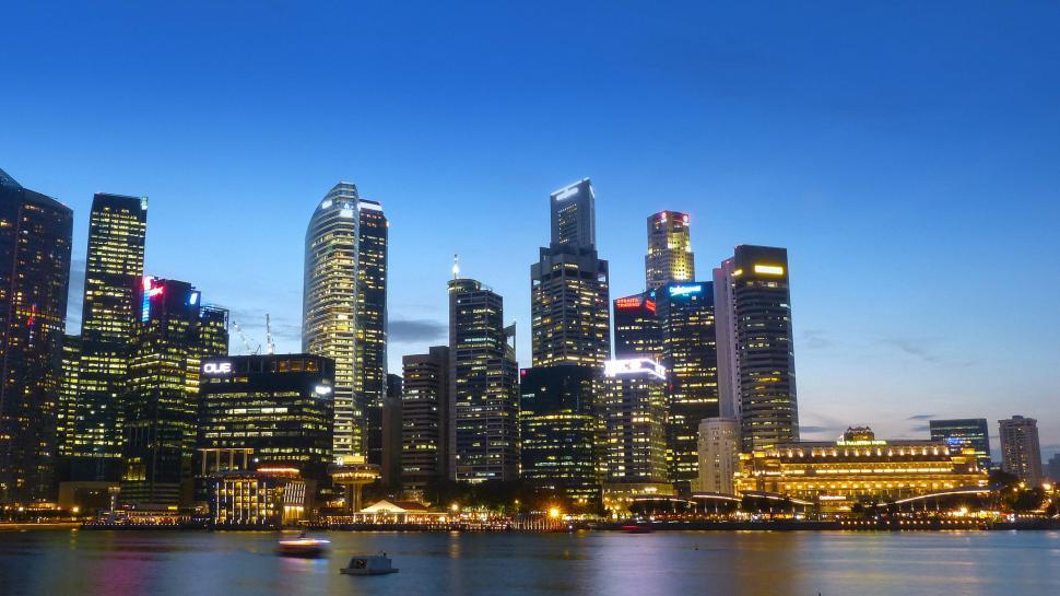 Free Image of City Skyline at Night With Boat in Water 