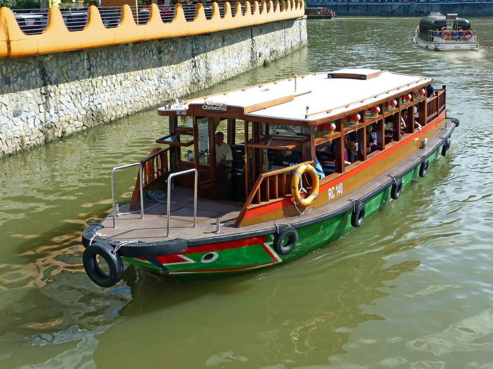 Free Image of Green and Red Boat Floating on Top of a Body of Water 