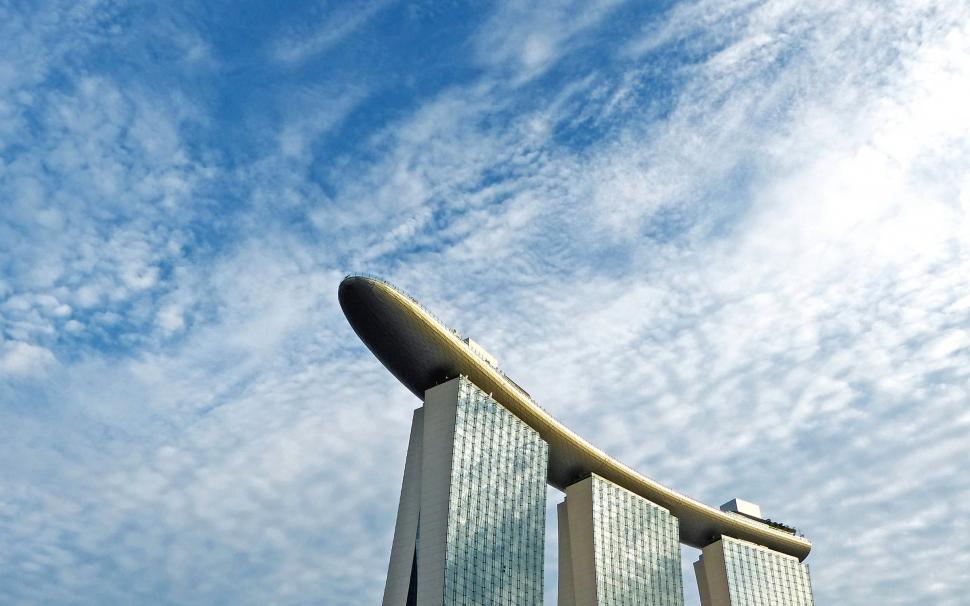 Free Image of Tall Building Below Cloudy Blue Sky 