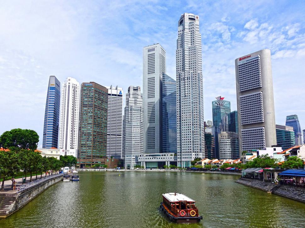 Free Image of Boat Traveling Down River Next to Tall Buildings 
