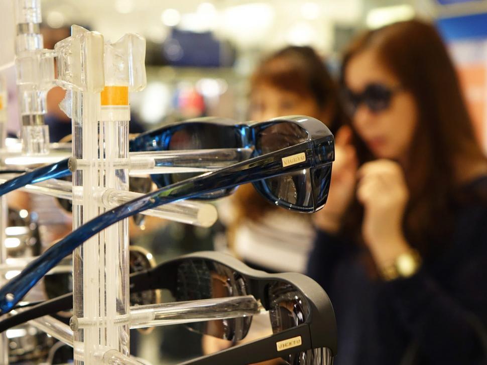 Free Image of Woman Examining Display of Glasses 