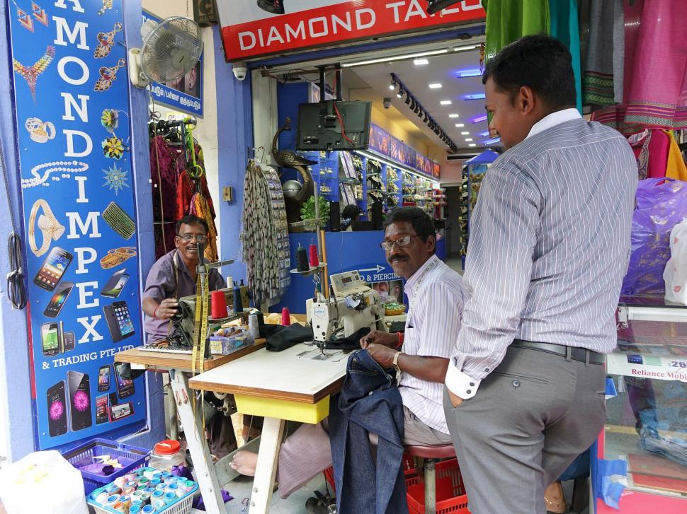 Free Image of Group of Men Sitting at Table Outside Store 