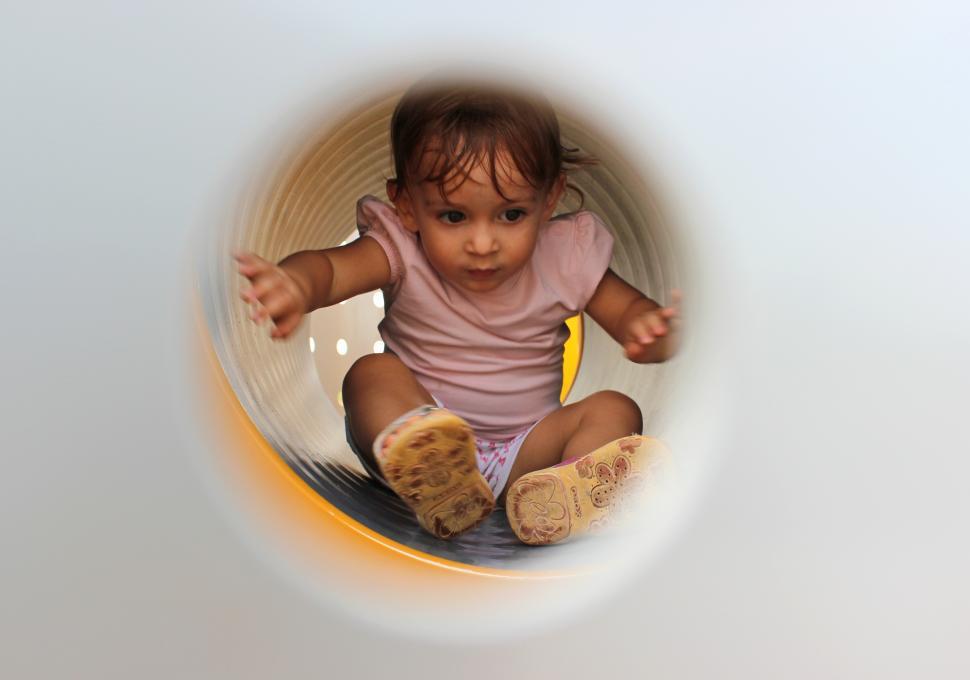 Free Image of Little Child Playing Inside Tube Playground 
