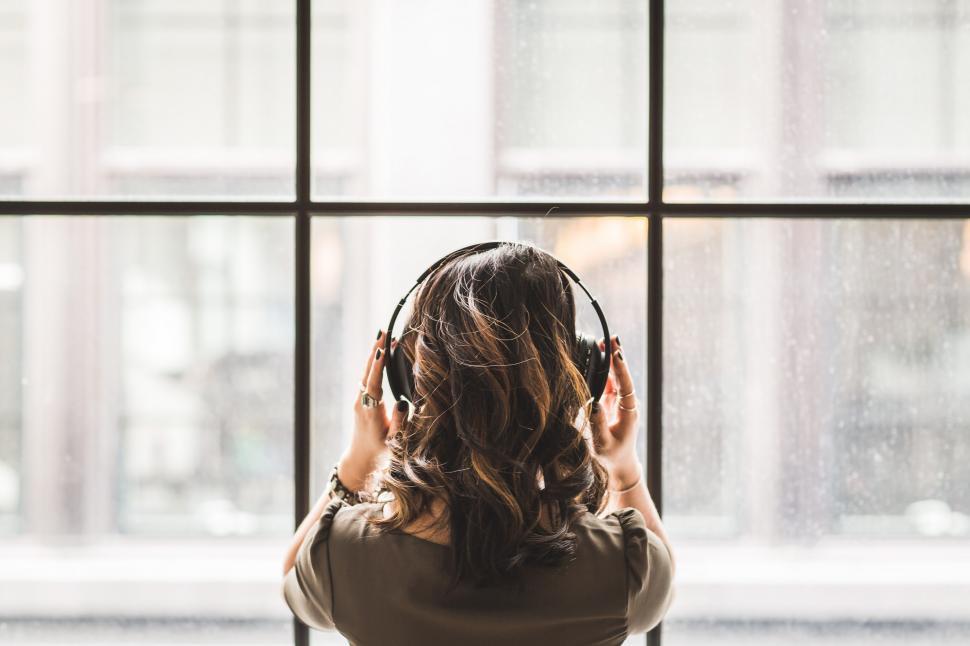 Free Image of Looking Out Window Wearing Headphones 