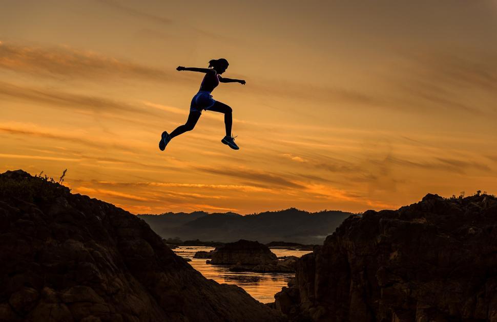 Free Image of Person Jumping Over Body of Water 