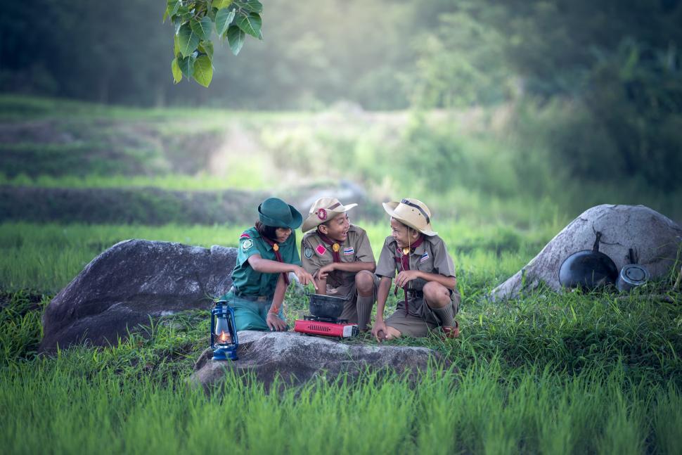 Free Image of Group of People Sitting on Top of Lush Green Field 