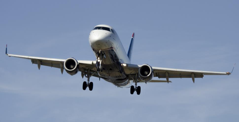 Free Image of Large Jetliner Flying Through a Blue Sky 