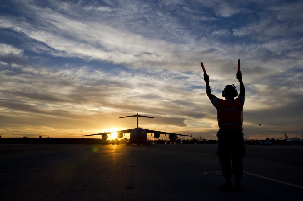 Free Image of Man Standing With Arms Raised in Parking Lot 