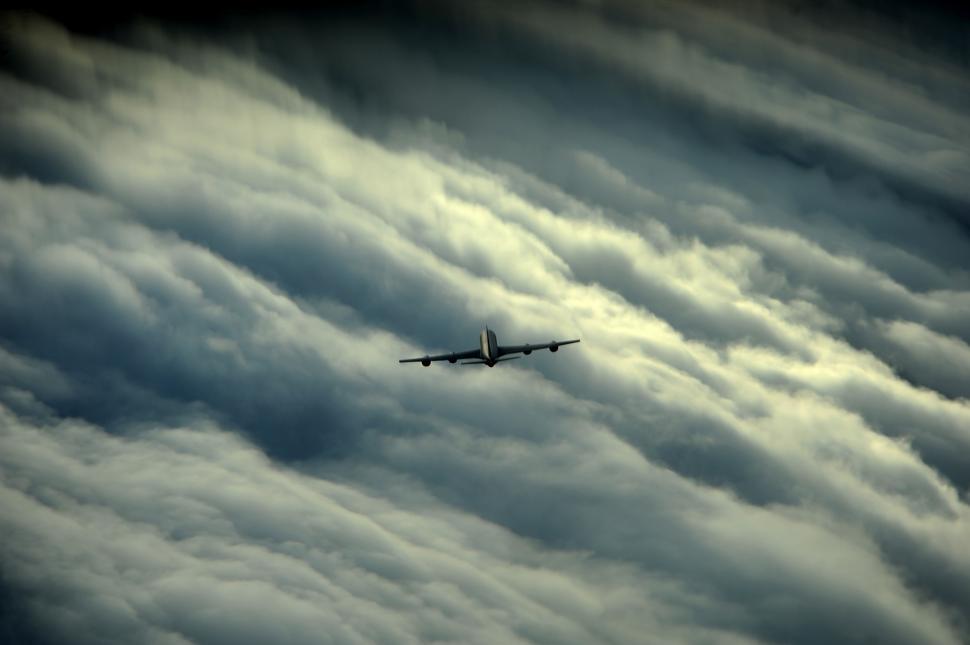 Free Image of Airplane Flying Through Cloudy Sky 