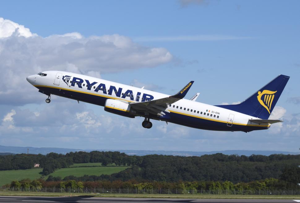 Free Image of A Large Jetliner Flying Through a Blue Cloudy Sky 